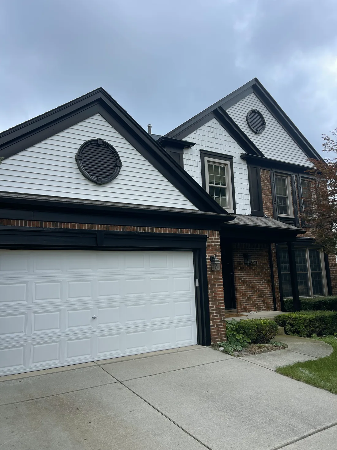 White siding with black trim and a black garage frame.