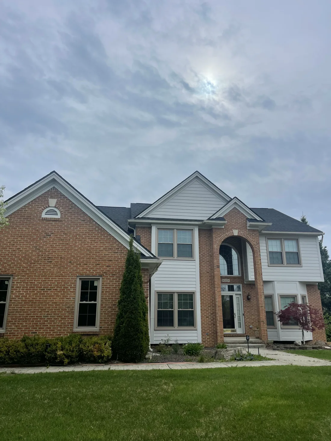 A brick and siding colonial with white trim.
